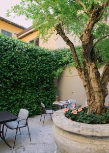 a patio with tables and chairs and a tree at Casa Gugù Room & Breakfast in Ravenna