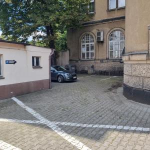 a car parked in a parking lot next to a building at Apartament Skarbowa 2 in Leszno