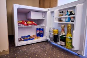 an open refrigerator with drinks and food in it at G Danube Boutique Hotel in Brăila