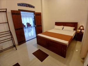 a bedroom with a bed and a room with a chair at Noel Villa in Galle