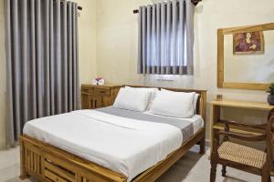 a bedroom with a bed and a chair and a window at Muthu Hiriketiya in Dickwella