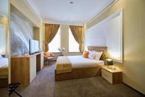 a hotel room with a bed and a tv at G Danube Boutique Hotel in Brăila +128 photos