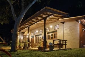 a house with a pergola at night at Muthu Hiriketiya in Dickwella
