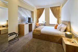 a hotel room with a bed and a tv at G Danube Boutique Hotel in Brăila