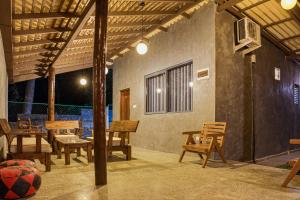 a patio with wooden chairs and tables in a building at Muthu Hiriketiya in Dickwella
