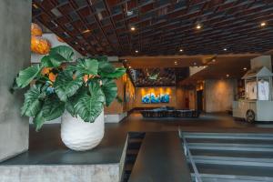 a large white vase with a plant in a room at ARTOTEL Sanur Bali in Sanur