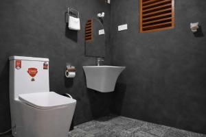 a bathroom with a toilet and a sink at Muthu Hiriketiya in Dickwella
