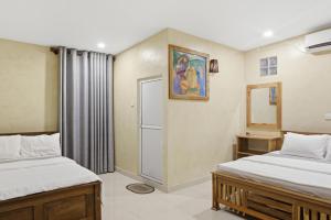 a bedroom with two beds and a door with a mirror at Muthu Hiriketiya in Dickwella +13 photos