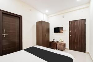 a bedroom with a bed and a cabinet and a television at Super Collection O Madhapur in Hyderabad +35 photos