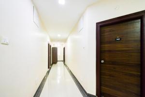 a hallway with a wooden door in a building at Super Collection O Madhapur in Hyderabad