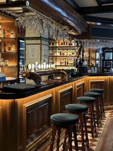 a bar with wooden bar stools in a restaurant at Hotel Bishops Arms Malmö in Malmö
