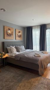 a bedroom with a large bed with blue curtains at HOOM Home & Hotel Sollentuna in Sollentuna