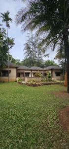 a house with a palm tree in front of a yard at Silver Oak Resort in Rājankunti
