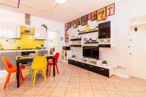 a kitchen with colorful chairs and a dining room at Black & White or Pop Art - Design Apartments with Parking & WiFi in Saronno