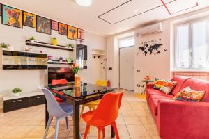 a living room with a red couch and a table at Black & White or Pop Art - Design Apartments with Parking & WiFi in Saronno
