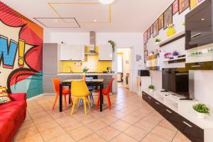 a kitchen and living room with a table and chairs at Black & White or Pop Art - Design Apartments with Parking & WiFi in Saronno