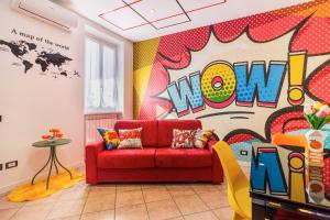 a living room with a red couch and a colorful wall at Black & White or Pop Art - Design Apartments with Parking & WiFi in Saronno