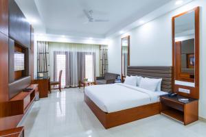 a bedroom with a bed and a flat screen tv at Silver Oak Resort in Rājankunti +31 photos