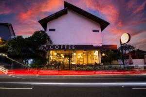 a building with a coffee shop on the side of a street at The Daun Bali in Canggu