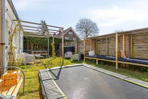 a backyard with a trampoline in the grass at DuoSuite Sand Vrouwenpolder in Vrouwenpolder +7 photos