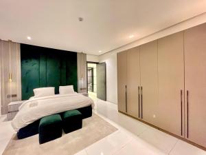 a bedroom with a large bed and a green wall at 2 Bedroom in Lekki phase 1 in Mama