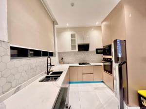 a kitchen with white cabinets and a refrigerator at 2 Bedroom in Lekki phase 1 in Mama