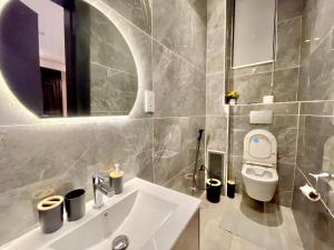 a bathroom with a sink and a toilet and a mirror at 2 Bedroom in Lekki phase 1 in Mama +6 photos