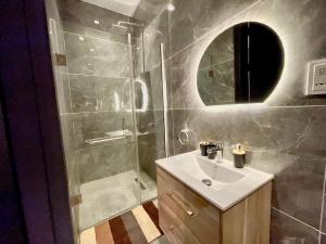 a bathroom with a sink and a shower with a mirror at 2 Bedroom in Lekki phase 1 in Mama