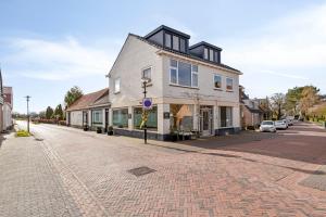 a white building on a cobblestone street at DuoSuite Sand Vrouwenpolder in Vrouwenpolder
