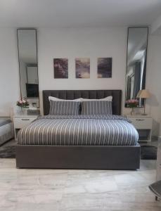 a bedroom with a large bed and two mirrors at Tiny home at the castle in Shkodër