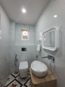 a bathroom with a sink and a toilet and a mirror at Hotel Niko International in Bodh Gaya