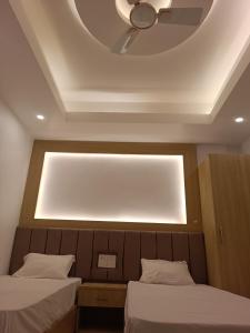 two beds in a room with a light on the ceiling at Hotel Niko International in Bodh Gaya +7 photos