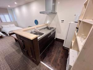 a kitchen with a sink and a bed in a room at 内町2階 1フロアまるごと貸切 高松中心部 4名まで in Takamatsu