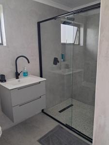 a bathroom with a glass shower and a sink at Oystercatcher Guest House in Wilderness +13 photos