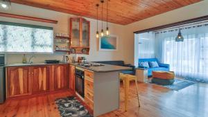 a kitchen with a counter top and a living room at Oystercatcher Guest House in Wilderness