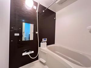a bathroom with a white tub and a sink at 内町2階 1フロアまるごと貸切 高松中心部 4名まで in Takamatsu