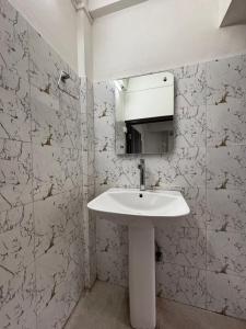 a bathroom with a white sink and a mirror at JKR residency in Shillong +193 photos