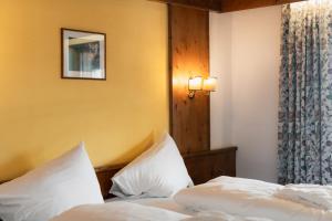 a bedroom with two beds with white pillows at Sporthotel Kurzras in Maso Corto