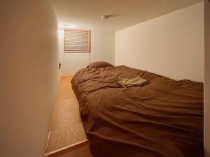 a bedroom with a bed in the corner of a room at hatago STAY Shinmachi in Nakatsugawa