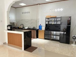 a large kitchen with a counter and a refrigerator at Zethira Homestay Syariah in Tabing