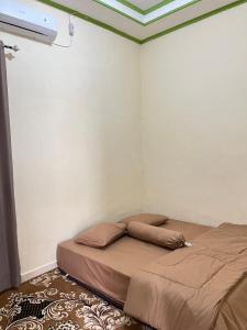 a bed in a corner of a room at Zethira Homestay Syariah in Tabing +5 photos