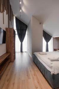 a bedroom with a large bed and large windows at Goldhill villa in Yaremche +34 photos