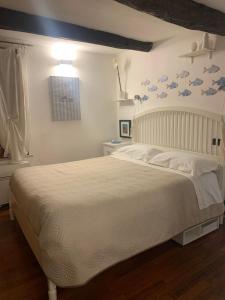 a bedroom with a white bed with blue birds on the wall at CASABARBARA lerici in Lerici
