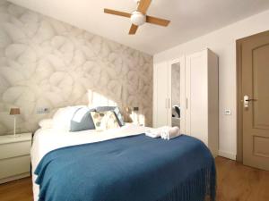 a bedroom with a blue bed with a ceiling fan at Isla de los Pensamientos in Faro de Cullera