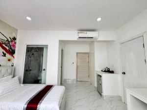 a white bedroom with a bed and a bathroom at Center Point Resident in Phnom Penh +1 photo