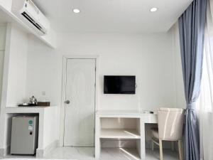 a white room with a desk and a tv at Center Point Resident in Phnom Penh