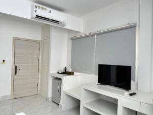 a white living room with a tv and a white table at Center Point Resident in Phnom Penh
