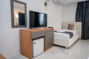 a living room with a television and a couch at District&Villa De Lago in Ohrid