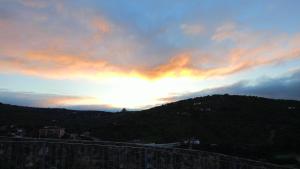 a sunset over a hill with the sun setting at Villa Marín in Aroche +4 photos