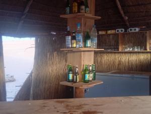a group of bottles sitting on a shelf in a bar at Etoile du Désert de Lompoul in Kébémèr